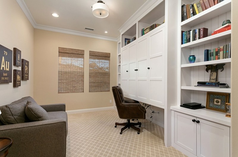 Remodeled office with carpet, fresh paint, which wall cabinets to store books, supplies, and work space