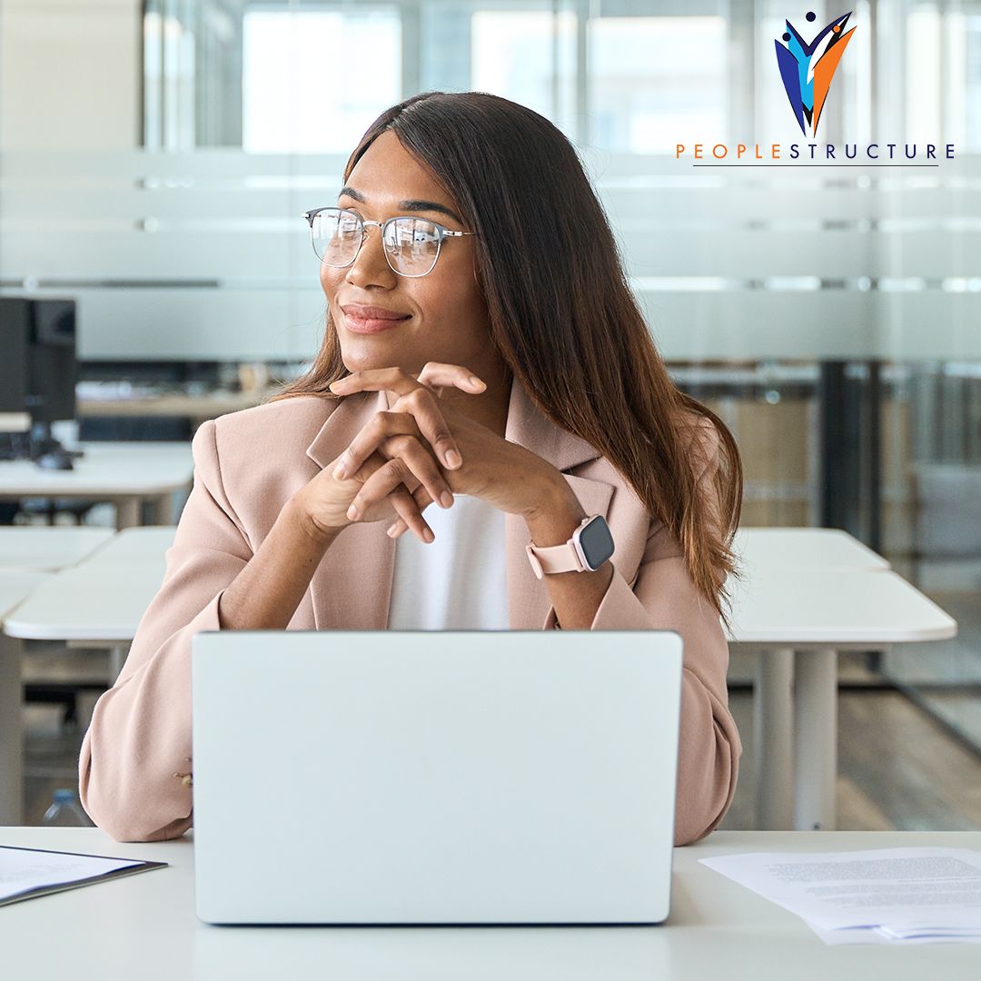 business woman sitting n front of laptop with hands clasped