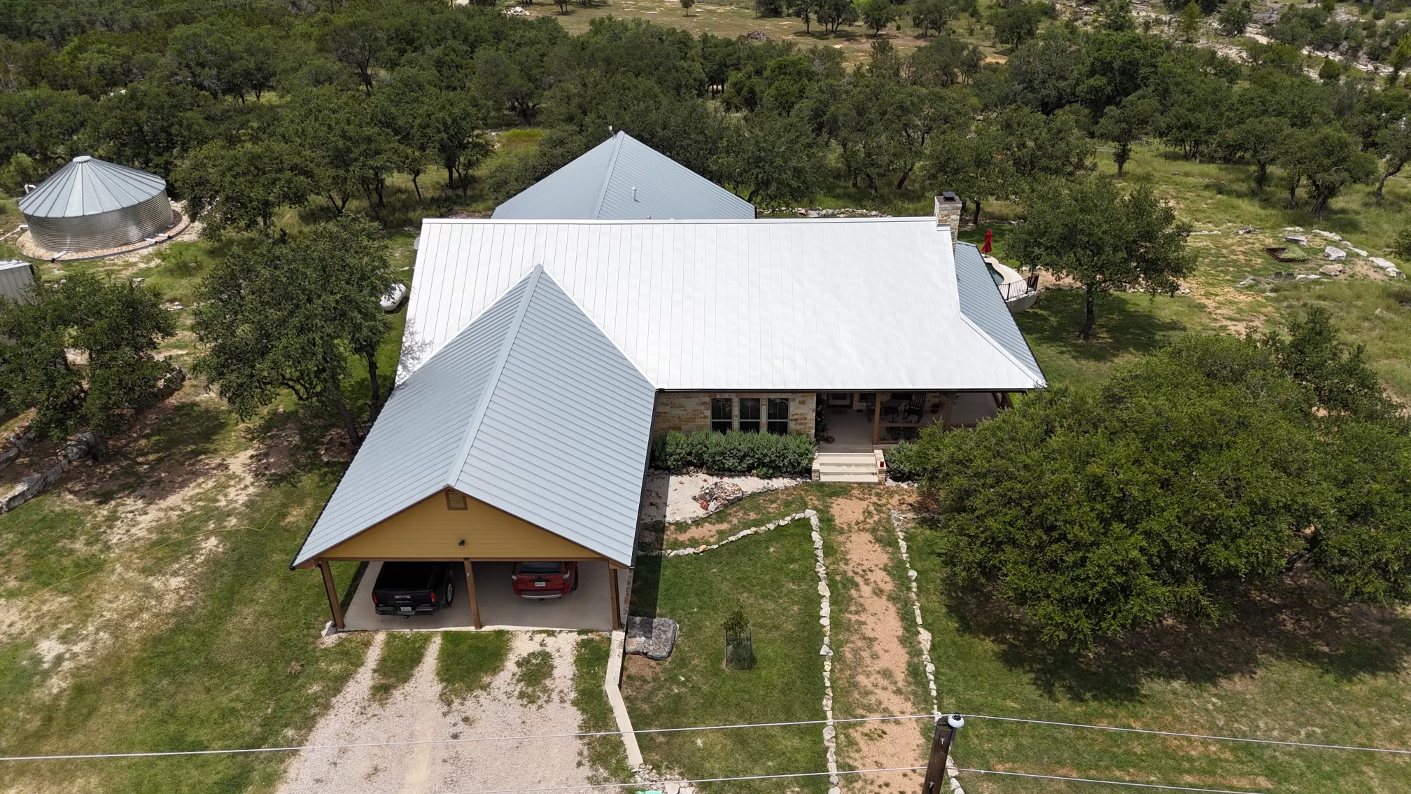 The overhead view of a singled roof with tarp covering sections of damage.