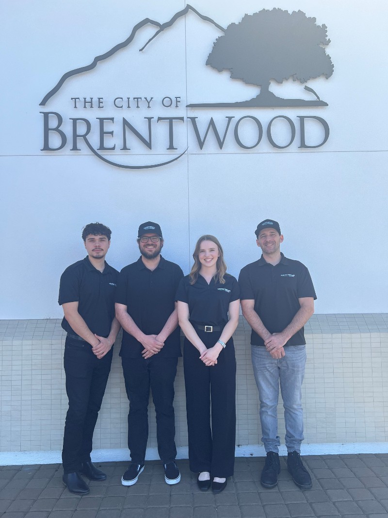 work team standing below sign