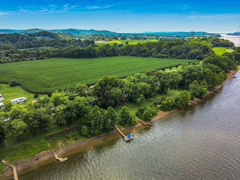 The scenic view of a river with colorful trees and a blue sky.