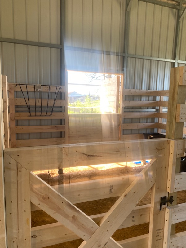 Newly built horse stalls with mounted hay feeders.