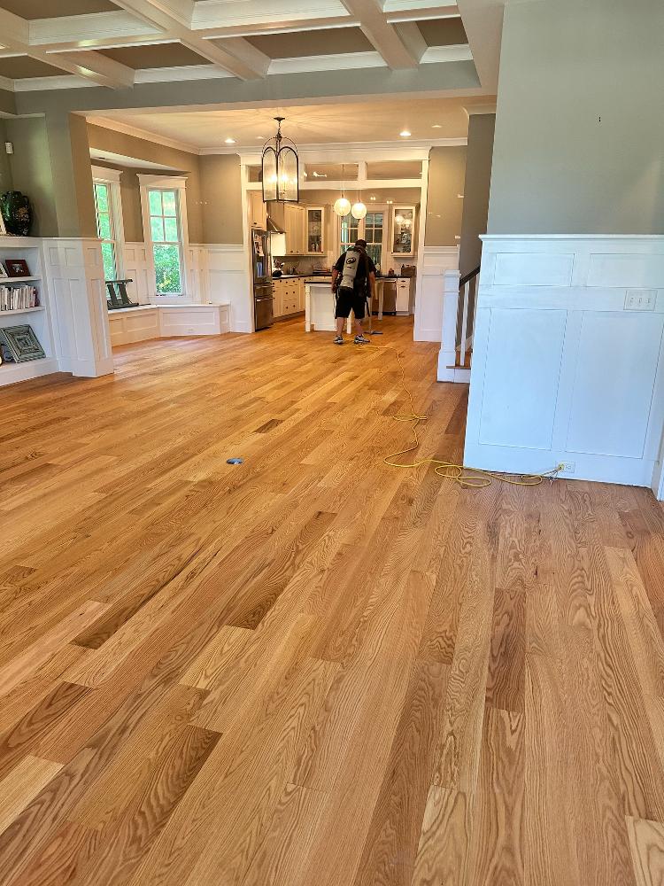 Flooring contractor working on residential hardwood flooring.