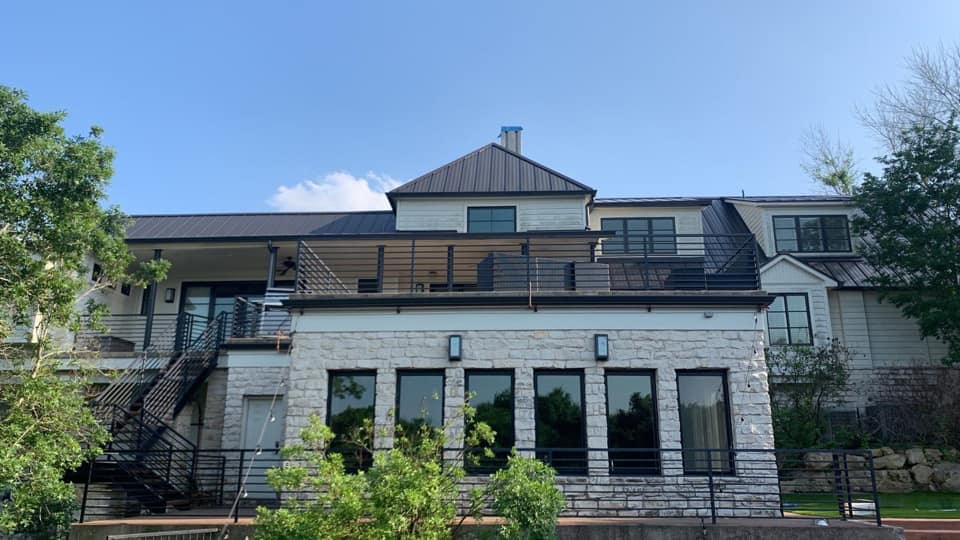 A modern, stone home with metal roofing.