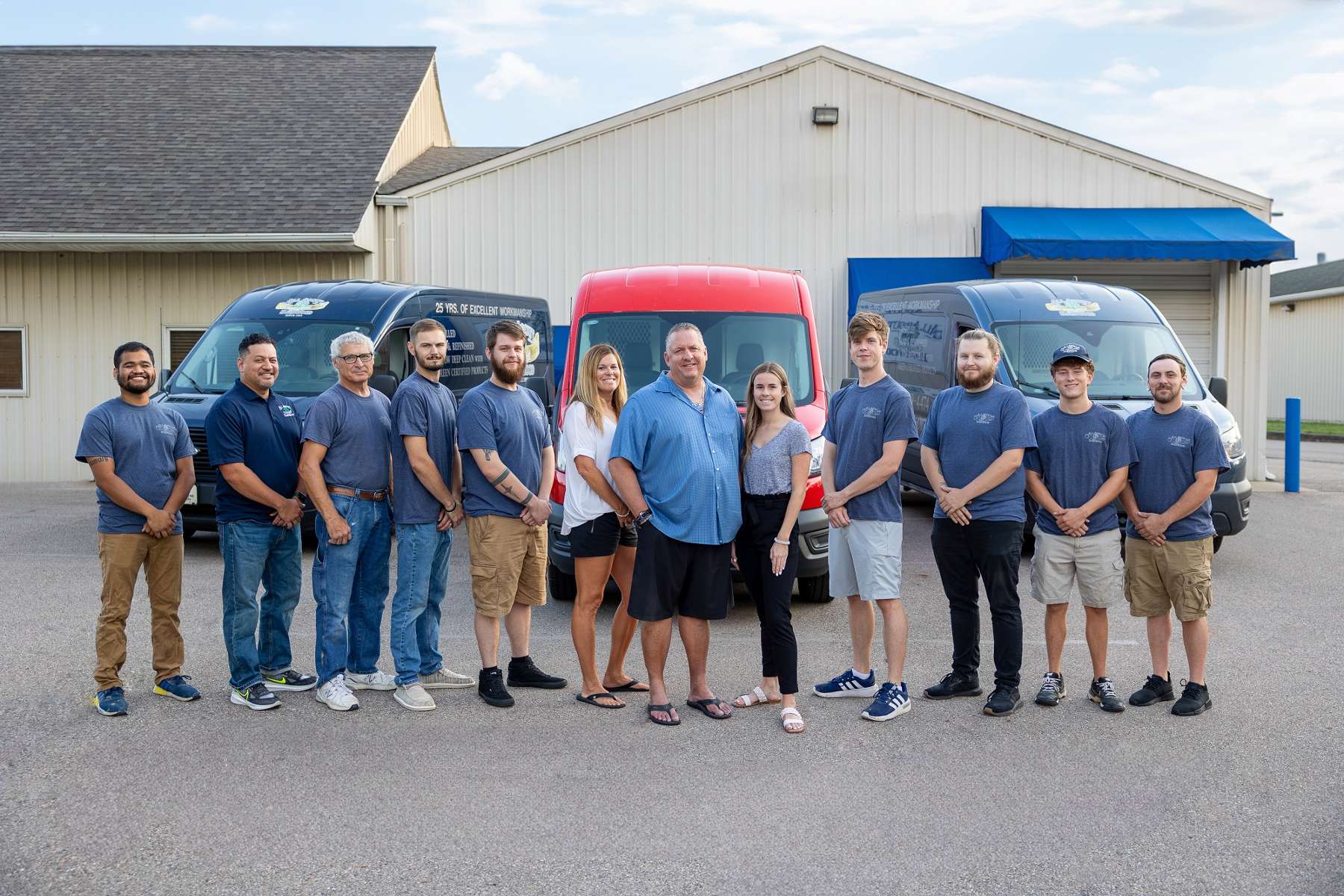 The staff at All About Hardwood Floor Company poses in front of thier storefront.