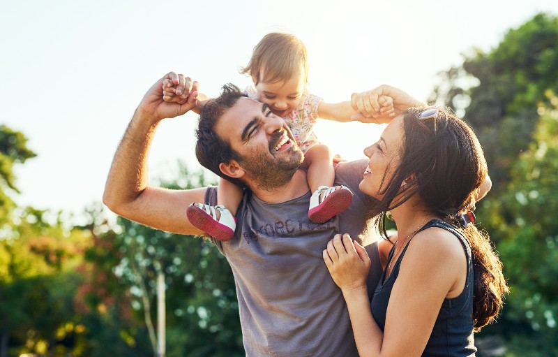 mom and dad with child smiling