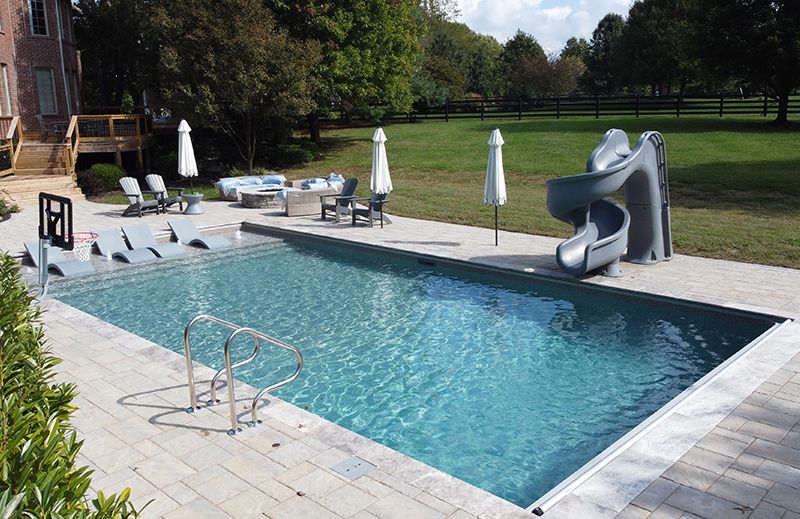 A backyard swimming pool with a twisty slide