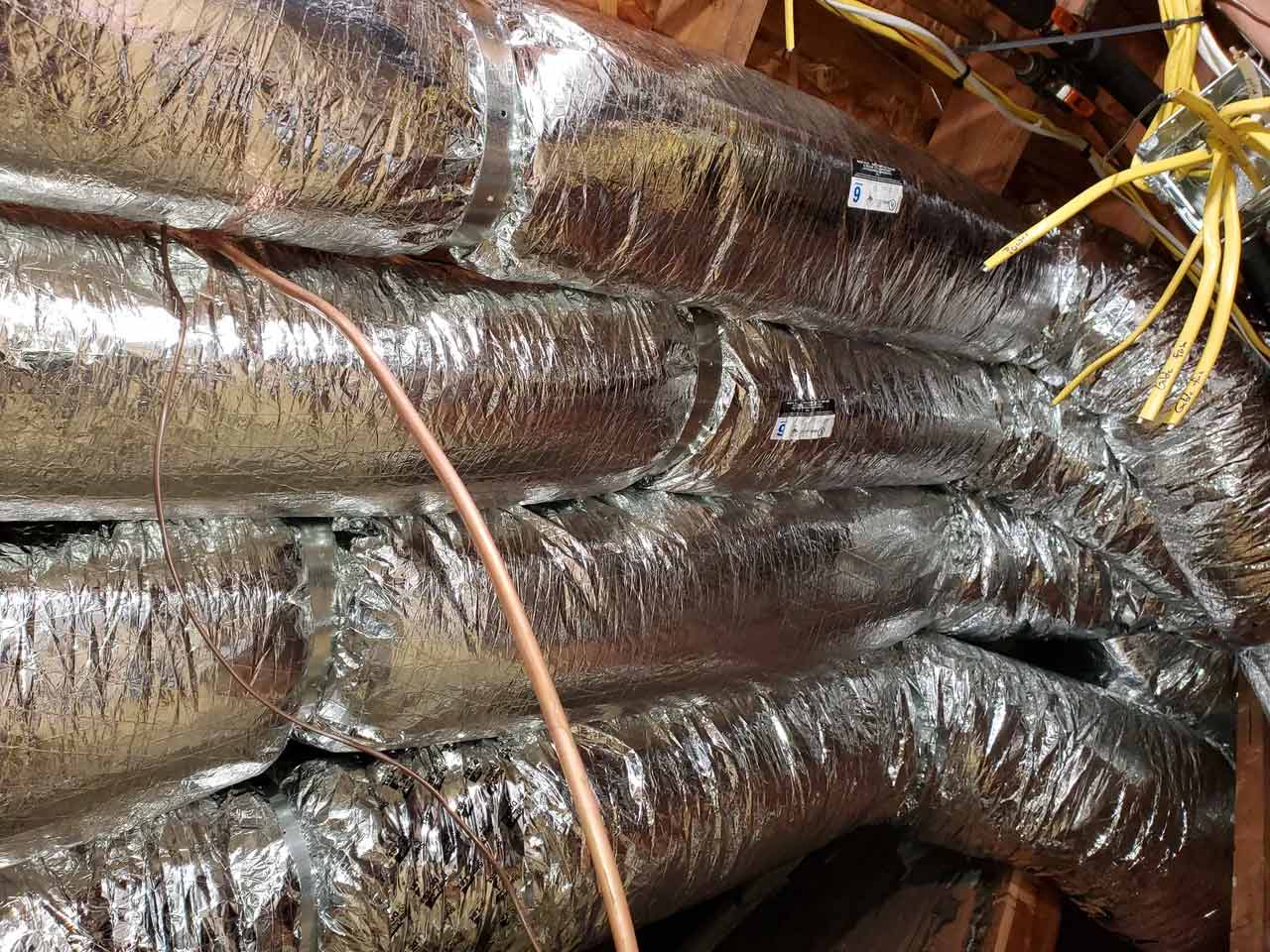 Multiple air ducts running through a home's attic.