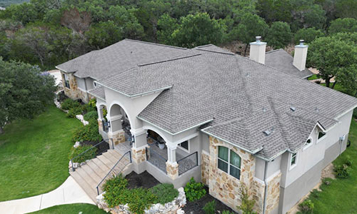A large home with a gray shingled roof.