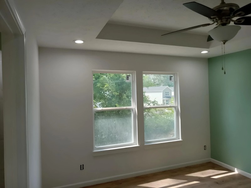 A bedroom with a window and a fresh paint job.