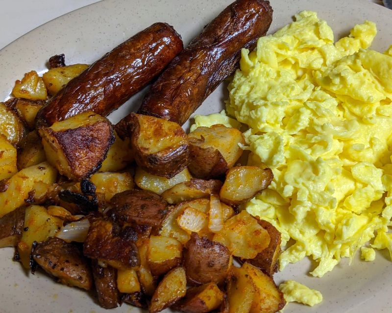 A plate of eggs, sausage, and home fries.