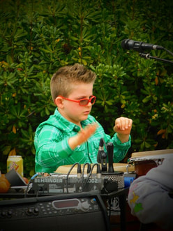 A young boy performs conducting motions.