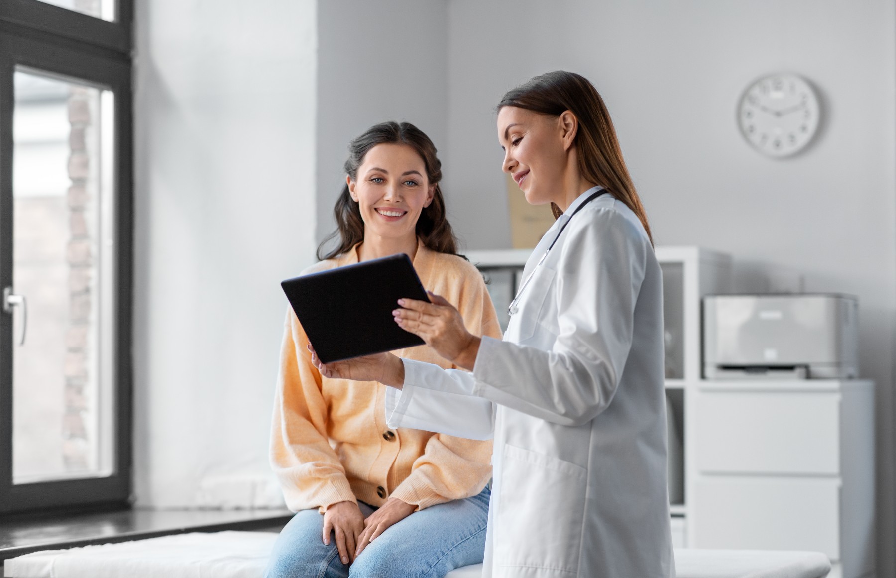 doctor looking at tablet with patient