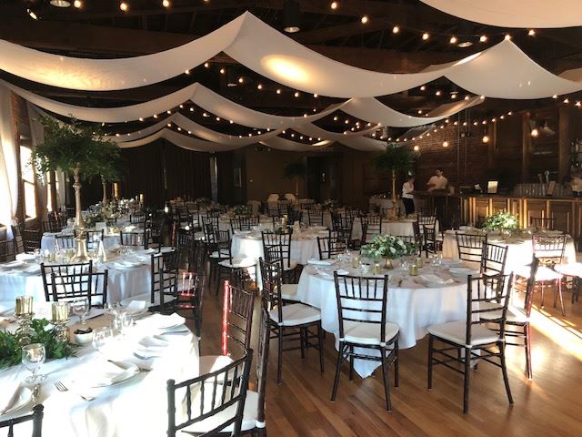 Event venue with round tables, chairs, and formal place settings