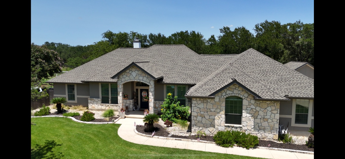 The overhead view of a singled roof with tarp covering sections of damage.