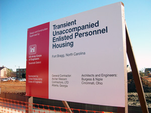 An outdoor sign erected on wooden poles for Transient Unaccompanied Enlisted Personnel Housing.