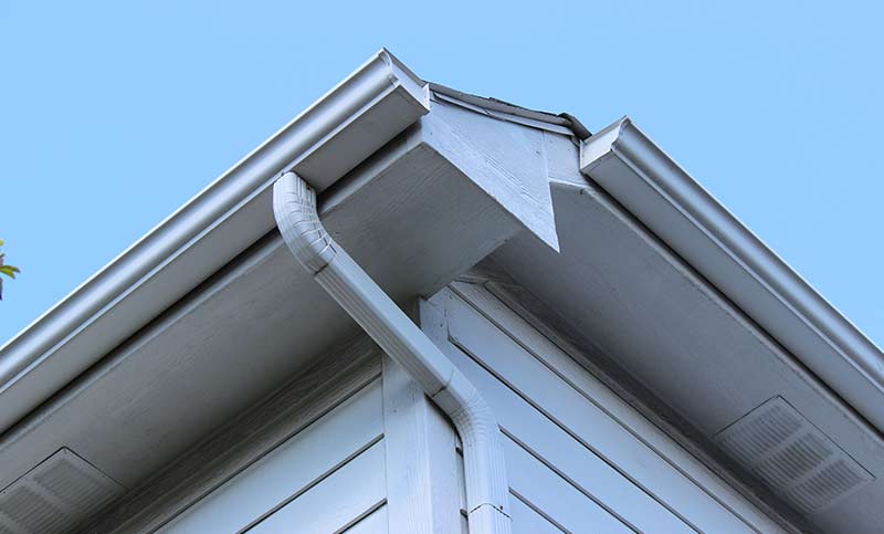 A corner gutter on a house needing repairs.