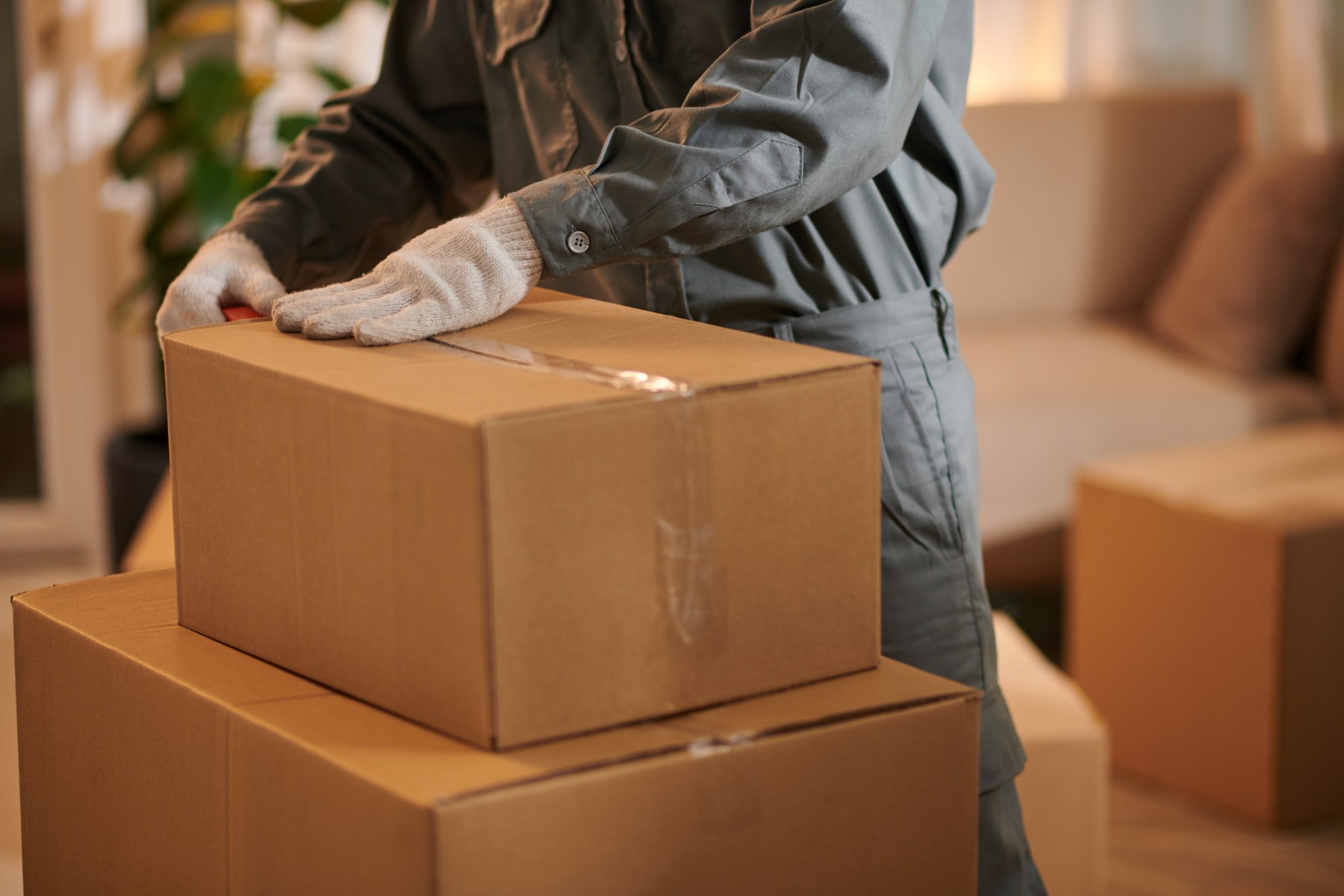 A man applies packing tape to a box.