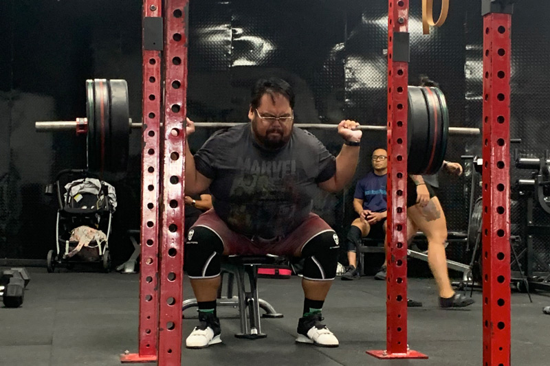 A powerlifter performs a heavy squat.