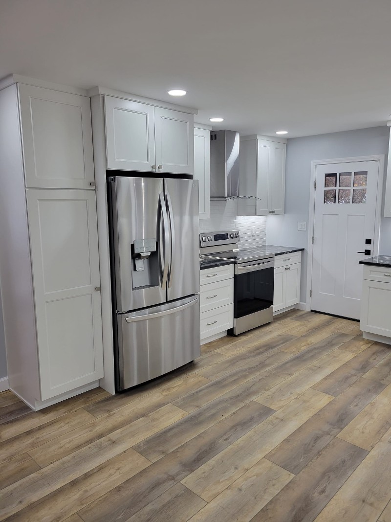 A handsome kitchen makeover with white cabinetry and luxury vinyl flooring.