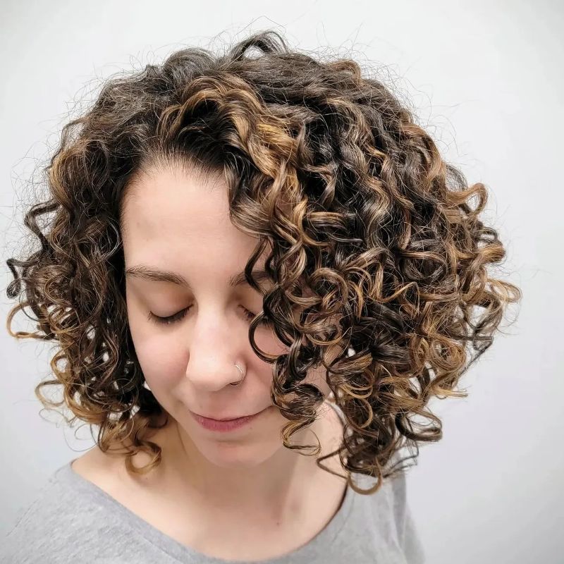 A young woman with a short, curly bob hair cut