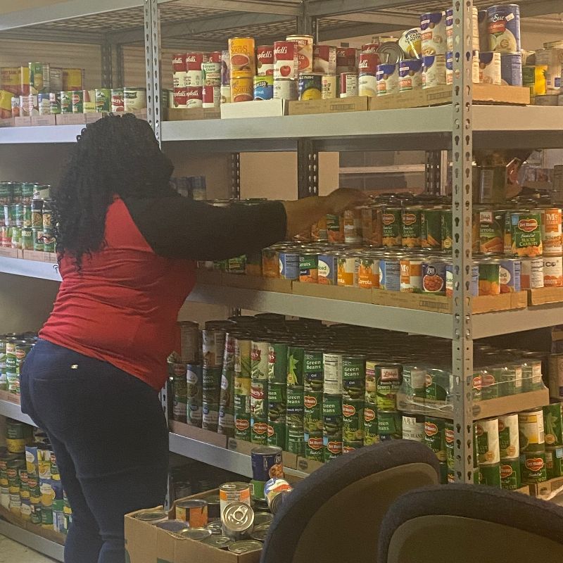 Woman stacking canned goods.