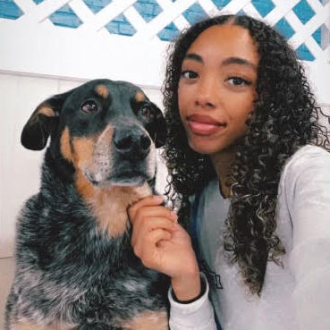 Madison Pemmberto poses with a black and tan dog.