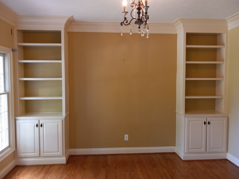 A freshly painted living room with bookcases surrounding an open space for an entertainment center.