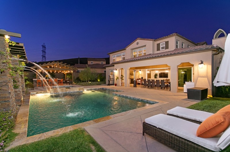 Rear of home with pool, fountain, and stone patio