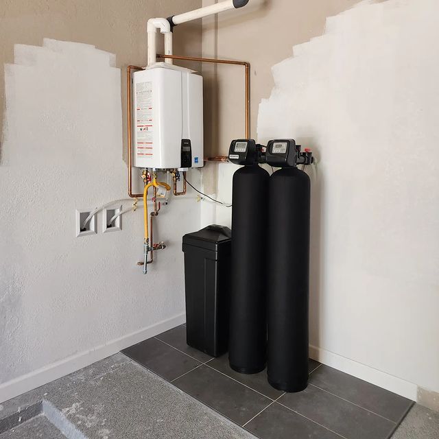A water softening system in the corner of a room.