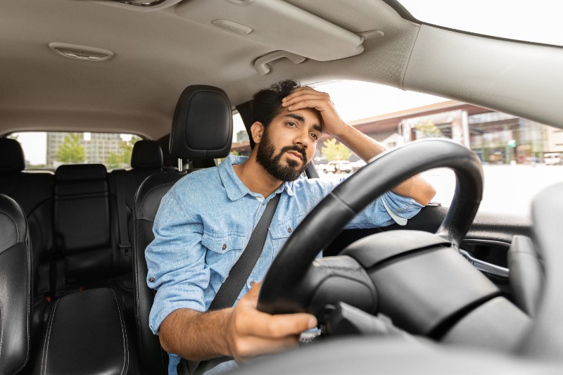 man behind the wheel of a car