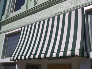 A green and white striped awning hangs over a business entrance.