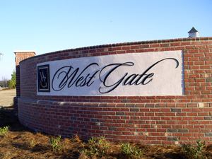 A banner for West Gate hangs on a brick wall.