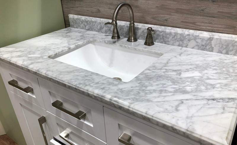 A sink with a white and gray marble countertop.