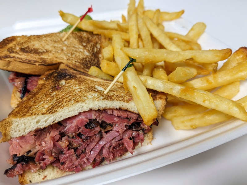 A corned beef sandwich with fries.