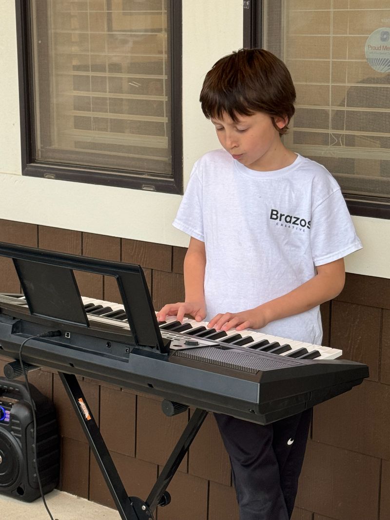 Young boy playing a keyboard.